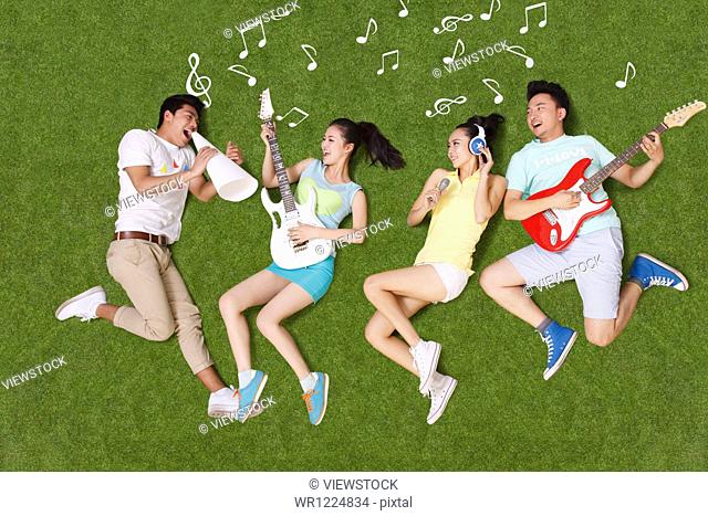 Young people on grass playing musical instruments