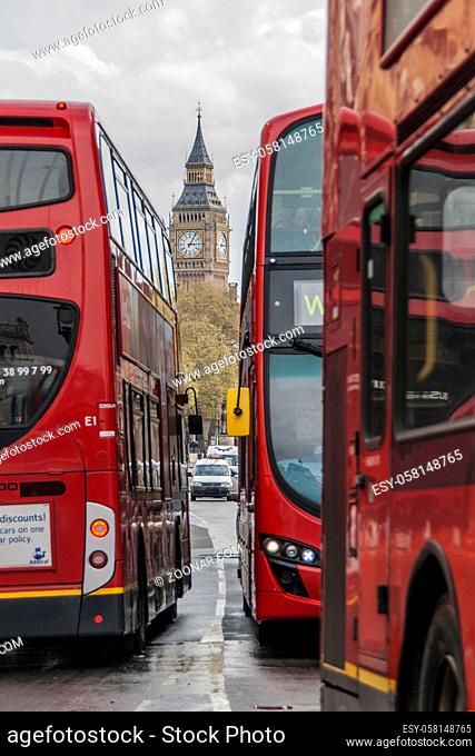 London street scene. Threebusses passing by and the Big ben in the background