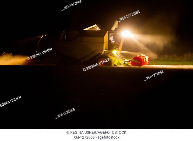 Combine Harvester, harvesting corn at night with lights on, Lower Saxony, Germany