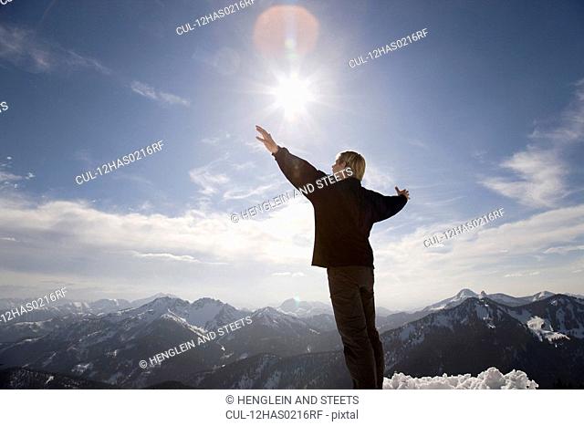man raising hands toward sky