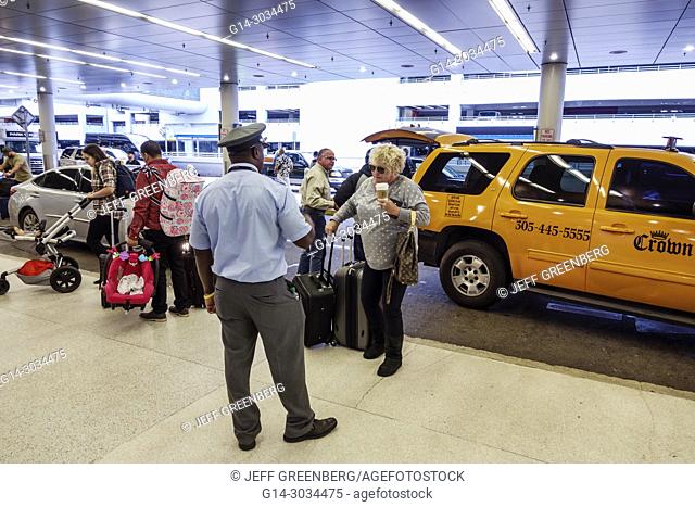 Florida, Miami, Miami International Airport MIA, terminal concourse gate area, departures, curb drop-off, Black, man, skycap, woman, passenger, luggage, taxi
