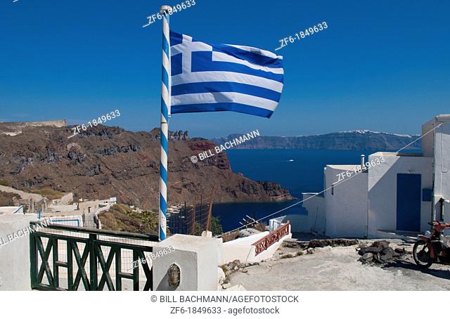 Flag flying from top of isolated village of Thirassia across from Santorini Greece in Greek Islands