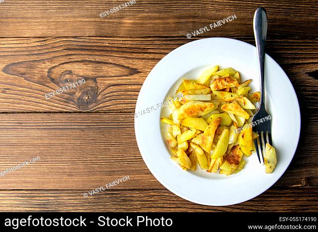 French fries on white dish on wooden background