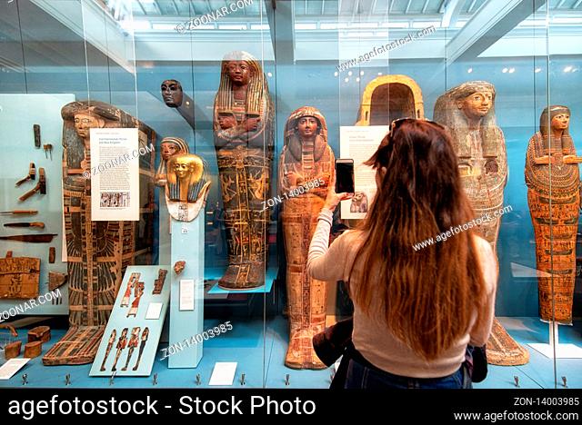 London, United Kingdom - May 13, 2019: The British Museum, London. Hall of Ancient Egypt, tourist taking a picture of ancient mummies exhibition