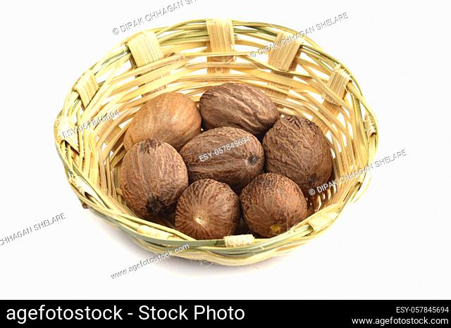 Nutmeg in bamboo basket isolated on white background