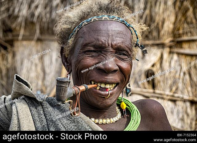 Old woman of the Jiye tribe smoking a pipe, Eastern Equatoria State, South Sudan, Africa