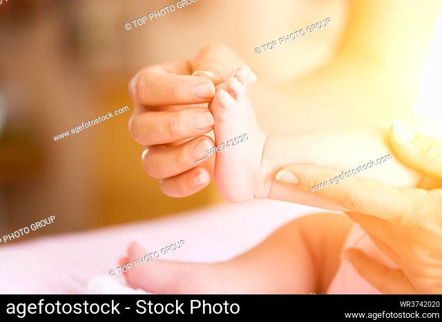 Baby with mother, she is holding her feet
