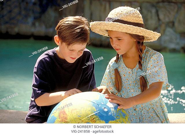 outdoor, half-figure, girl with summerdress and strawhat and freckeled boy, 7-8 years old, sit beside a waer pool studying the globe printed on a waterball  -...