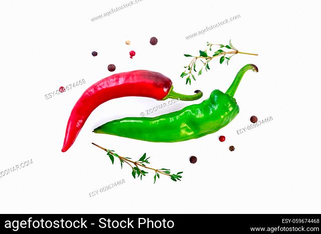 Pods of green and red hot pepper, two sprigs of thyme and peas of colored pepper isolated on a white background