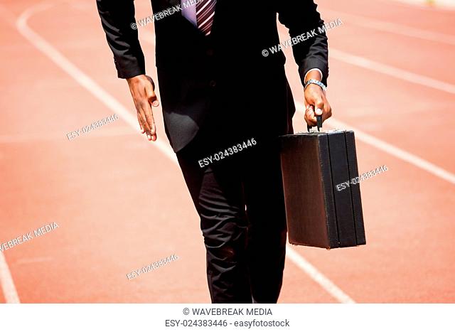 Mid section of businessman running on a running track