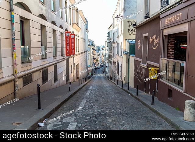 Paris, France, March 26, 2017: View on narrow cobbled street among traditional parisian buildings in Paris, France