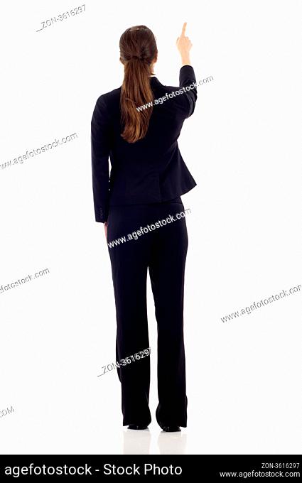 Full body of young business woman pointing at something in her back, isolated on white background