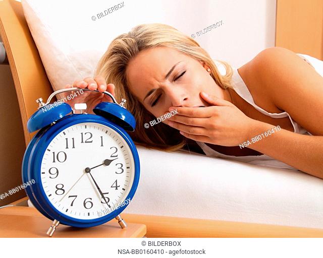 Sleeplessness, clock at night. Woman cannot sleep