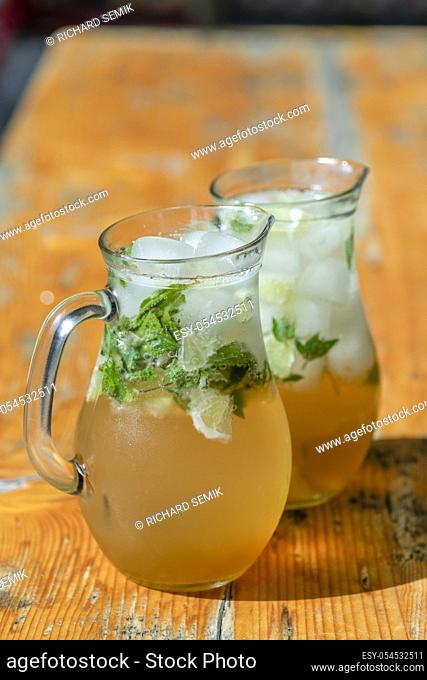 two mugs with mojito on wooden table