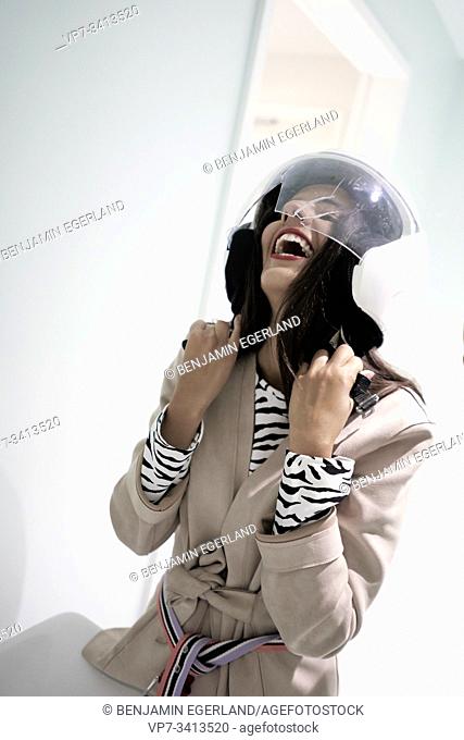 happy woman wearing broken crash helmet in highway rest stop
