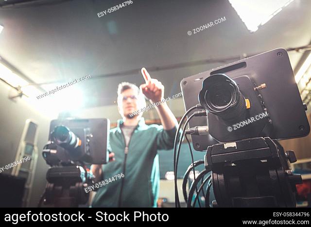 Male cameraman is operating a film camera in a television recording studio