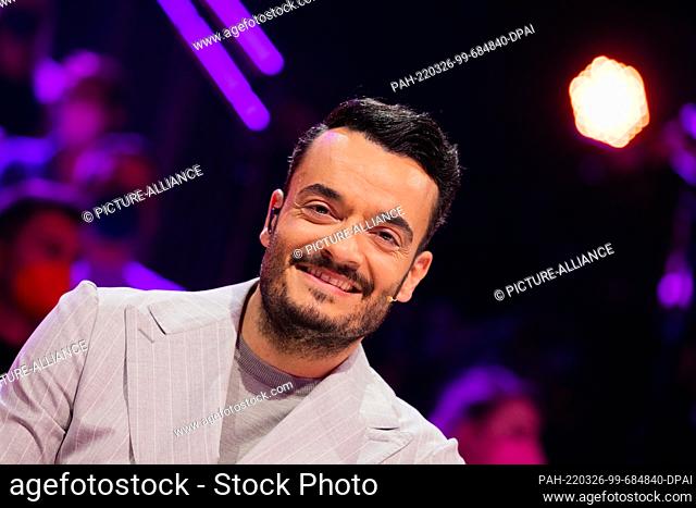 26 March 2022, North Rhine-Westphalia, Cologne: Giovanni Zarrella from the guessing team sits at the guessing desk in the Prosieben show ""The Masked Singer""