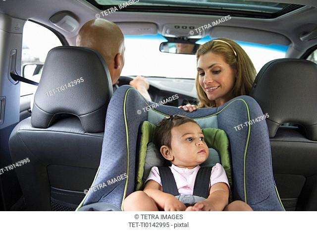 Young family with small girl 12-18 months sitting in car