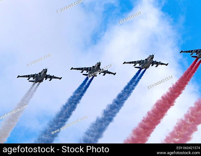 MOSCOW, RUSSIA - MAY 7, 2021: Avia parade in Moscow. Group of Russian fighters Sukhoi Su-25 with painted russian flag in the sky on parade of Victory in World...
