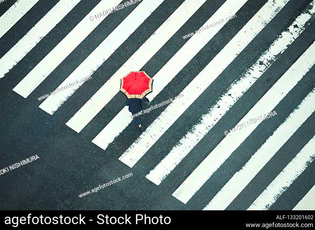 People Crossing A Crossroad On A Rainy Day In Tokyo, Japan