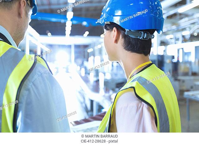Workers in reflective clothing and hard-hat in factory