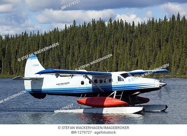Taxiing de Havilland Canada DHC-3 Otter, Floatplane, Canoe tied to float, bush plane, Caribou Lakes, upper Liard River, Yukon Territory, Canada