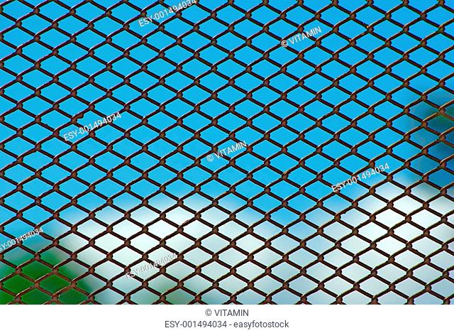 Rusty fence on blue sky