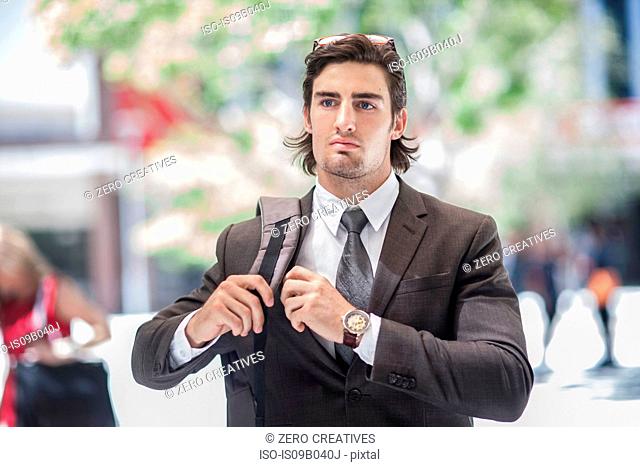 Young confident businessman walking in city