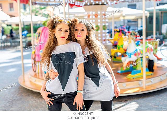 Fashion blogger twins in front of carousel, Mantova, Lombardia, Italy