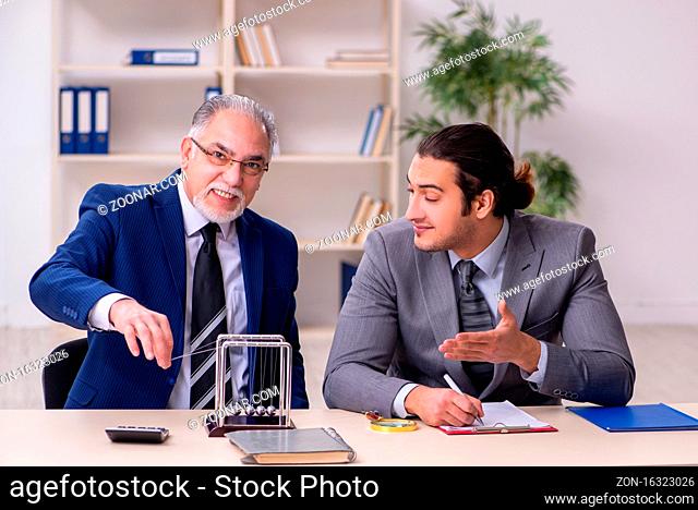 Two businessmen and meditation balls on table