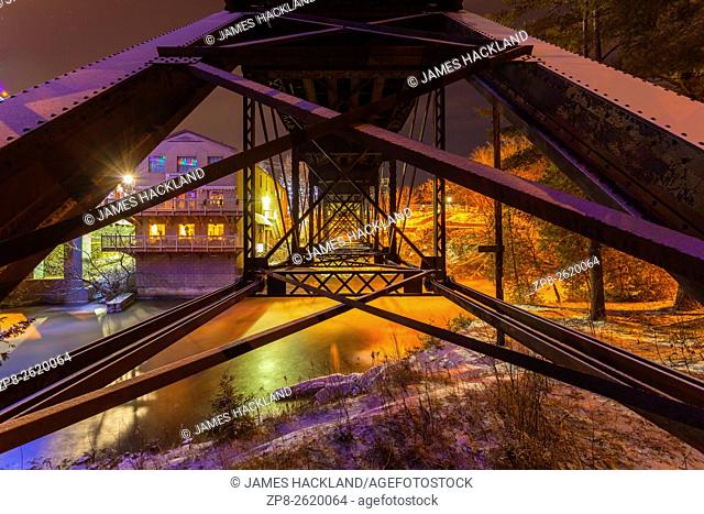 Underneath a pratt truss rail bridge spanning the Muskoka River. Bracebridge, Muskoka, Ontario, Canada
