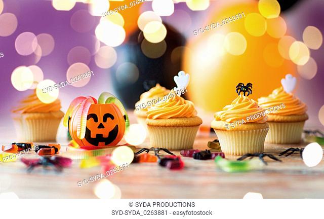 halloween party decorated cupcakes on wooden table