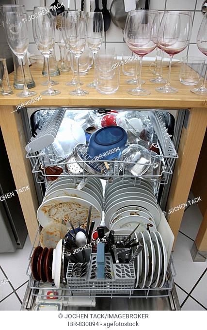 Dirty dishes in a dishwasher and on counter top