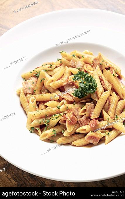 penne amatriciana tomato and ham sauce pasta on wood table background