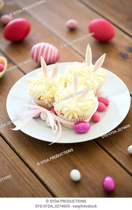 cupcakes with easter eggs and candies on table