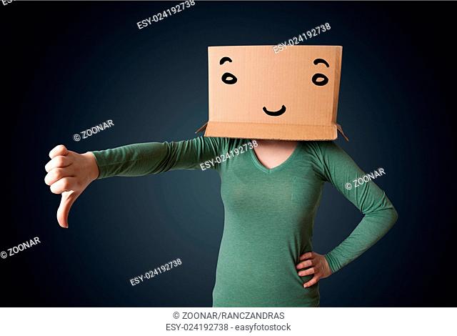 Young woman gesturing with a cardboard box on her head with smiley face