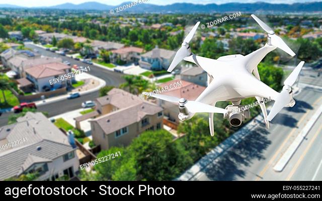 Unmanned Aircraft System (UAV) Quadcopter Drone In The Air Over Residential Neighborhood