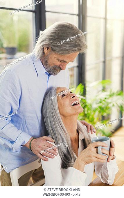 Happy senior couple drinking coffee at home