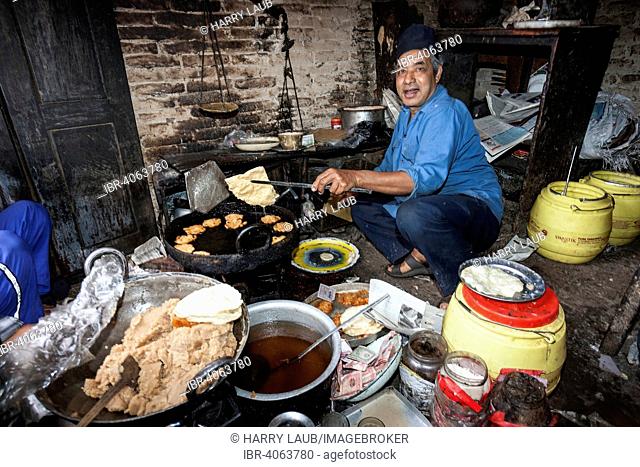 Nepalese man producing fried food, Bhaktapur, Nepal