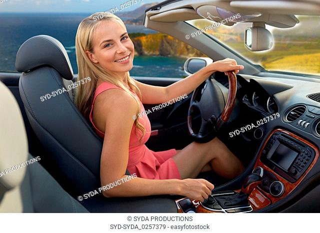 woman driving convertible car on big sur coast