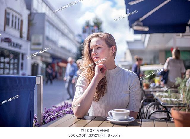 A young woman sitting outside a cafe