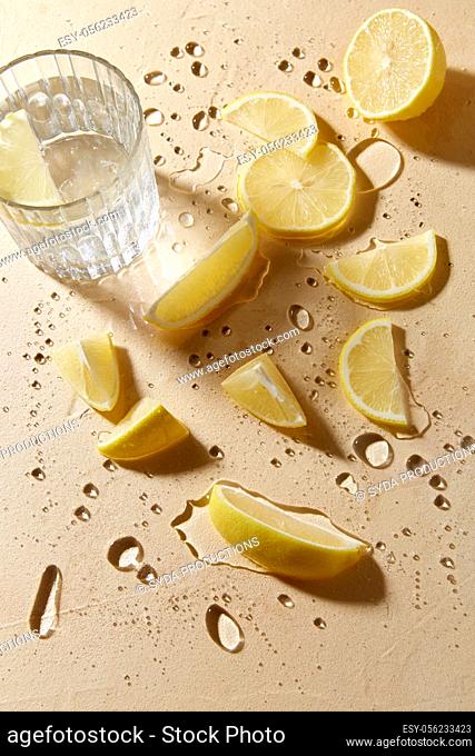 glass of water and lemon slices on wet table