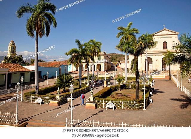 square Plaza Mayor with the Church of the Holy Trinity, Museo Romantico and bell tower of the Convento de San Francisco and on the in Trinidad, Cuba, Caribbean