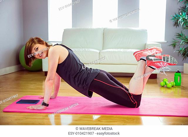 Fit woman doing press up on mat