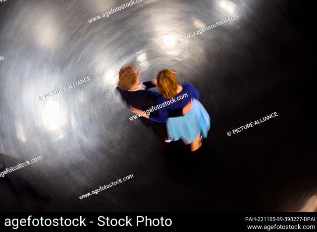 05 November 2022, Berlin: A couple dances at a free swing or Lindy Hop dance class to warm up in the foyer of the Deutsche Oper