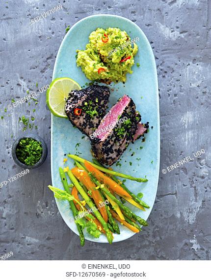 Tuna in a black sesame seed coating with guacamole and an asparagus and pepper meldey