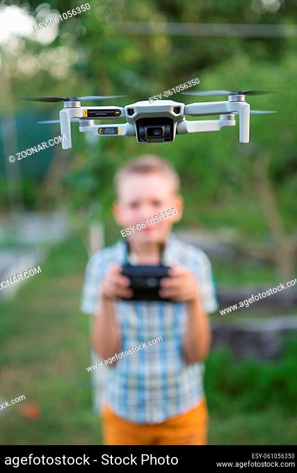 Kid flying drone. Boy operate drones. Child Operating Quadcopter. Little Pilot Using Drone Remote Controller