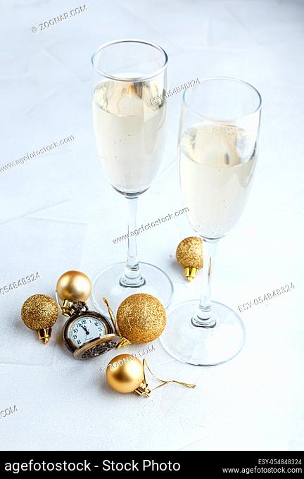 Midnight celebration of the new year with pocket watch and champagne glasses