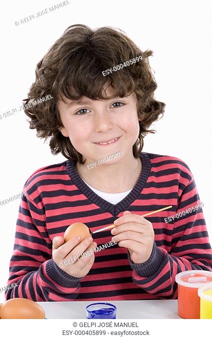 Child adorable adorning Easter eggs