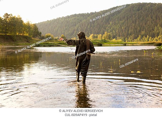 Mid adult man fishing in river, Sarsy village, Sverdlovsk Region, Russia